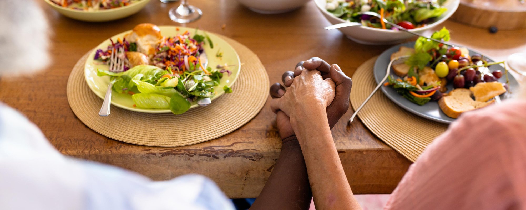 Residents sharing a meal and holding hands