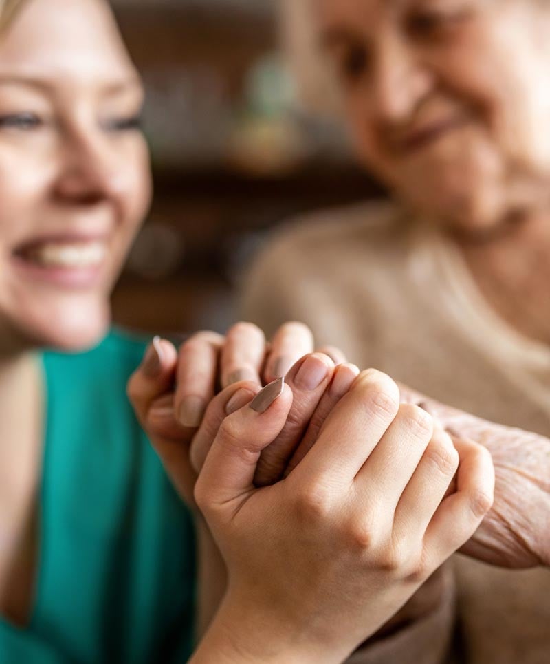 Caregiver holding hands with a senior resident
