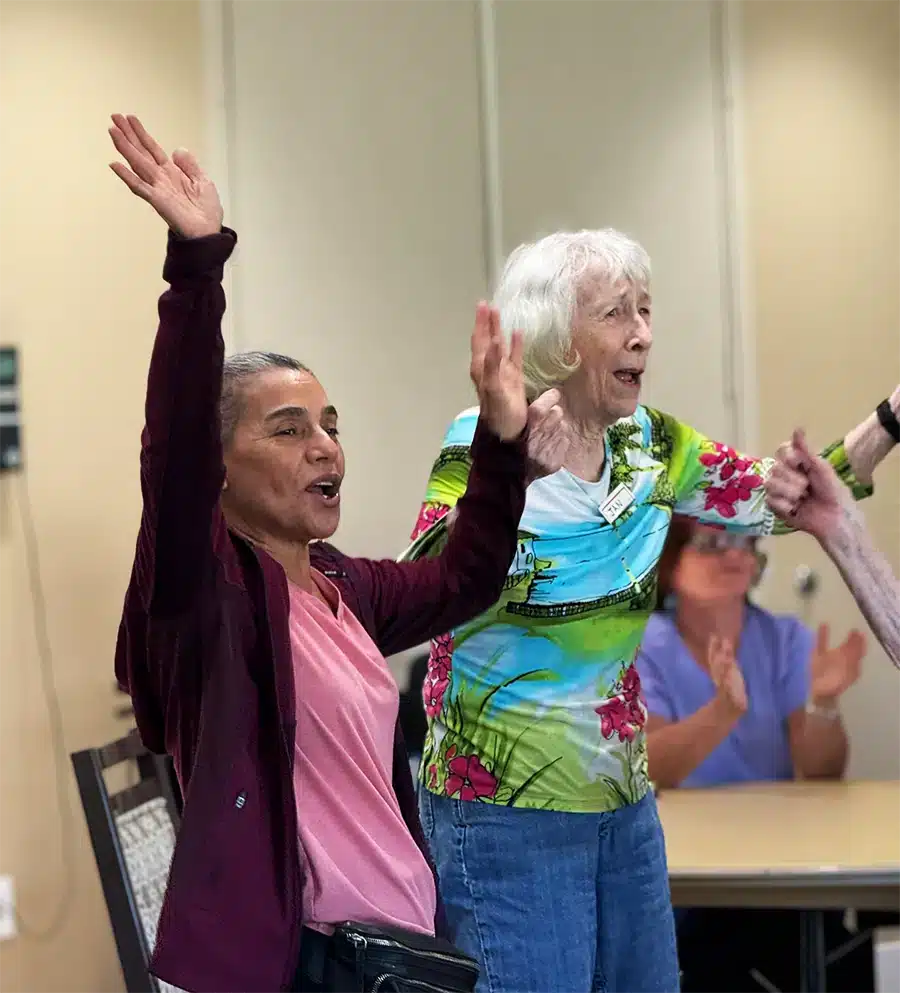Residents enjoying a lively activity with raised hands