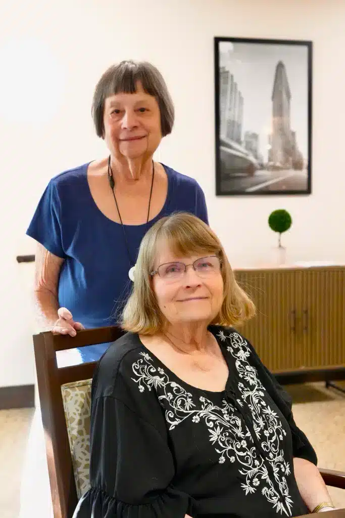 Two residents posing in a common area