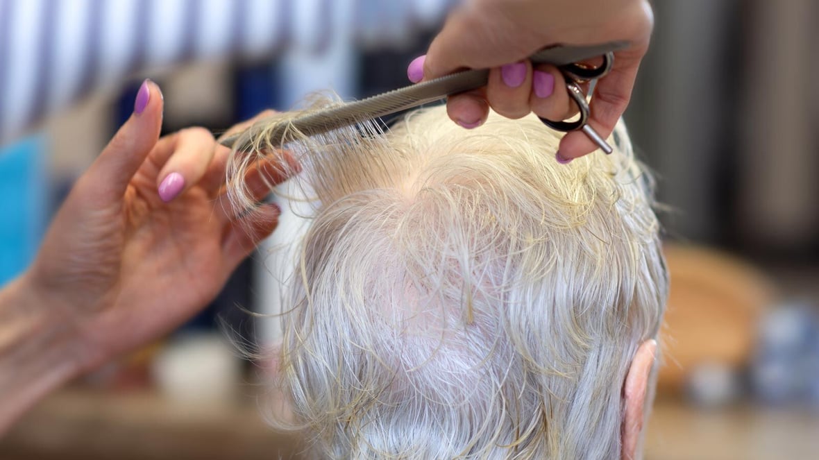 Stylist cutting hair for a senior resident.
