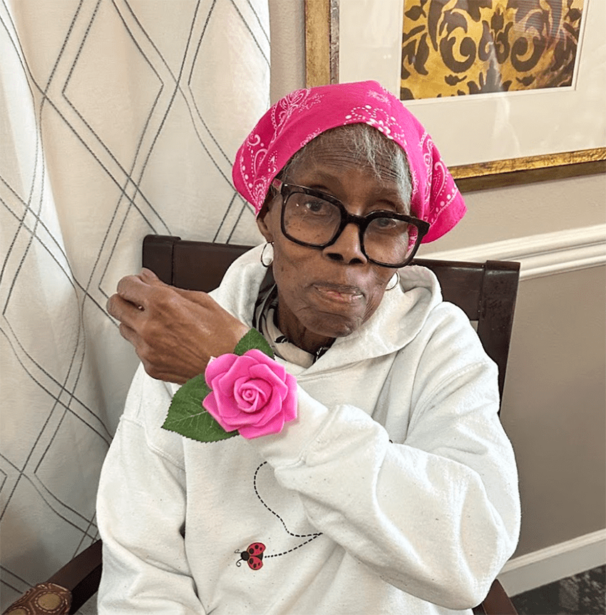 Resident with a pink rose on their wrist in the facility