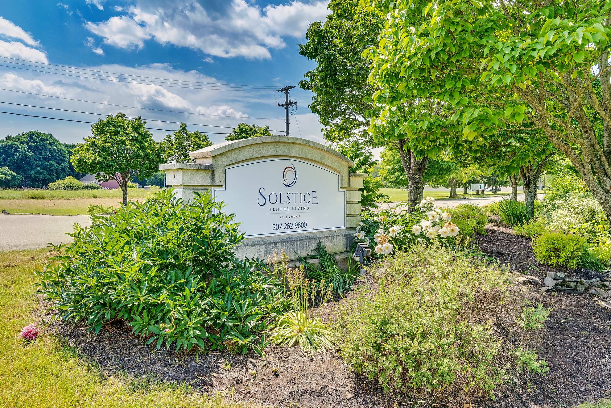 Exterior sign for Solstice Senior Living at Bangor surrounded by greenery