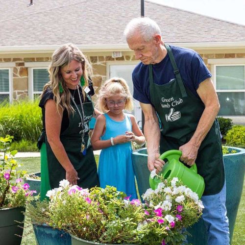 Residents and staff gardening together outdoors