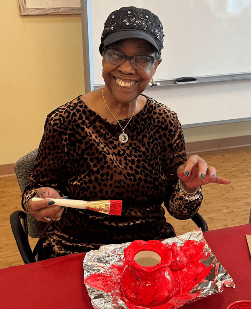 Resident painting a ceramic piece during an activity