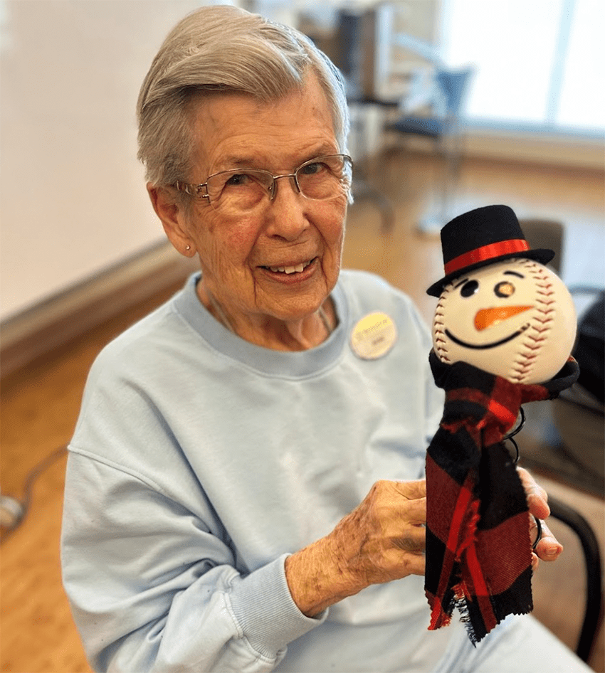 Resident enjoying a craft project with a snowman figure
