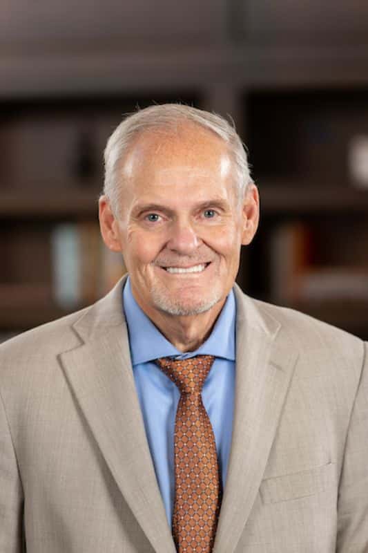 Smiling resident in a suit with a well-lit background