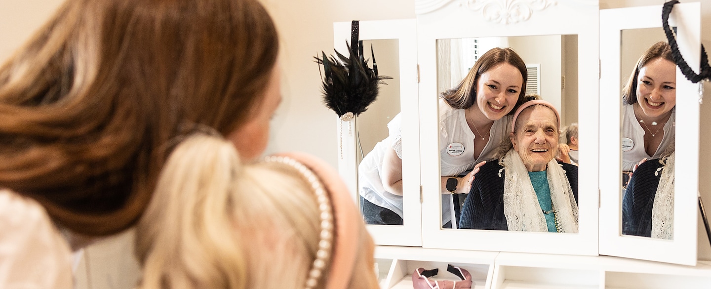 Staff member assisting a resident at a mirror