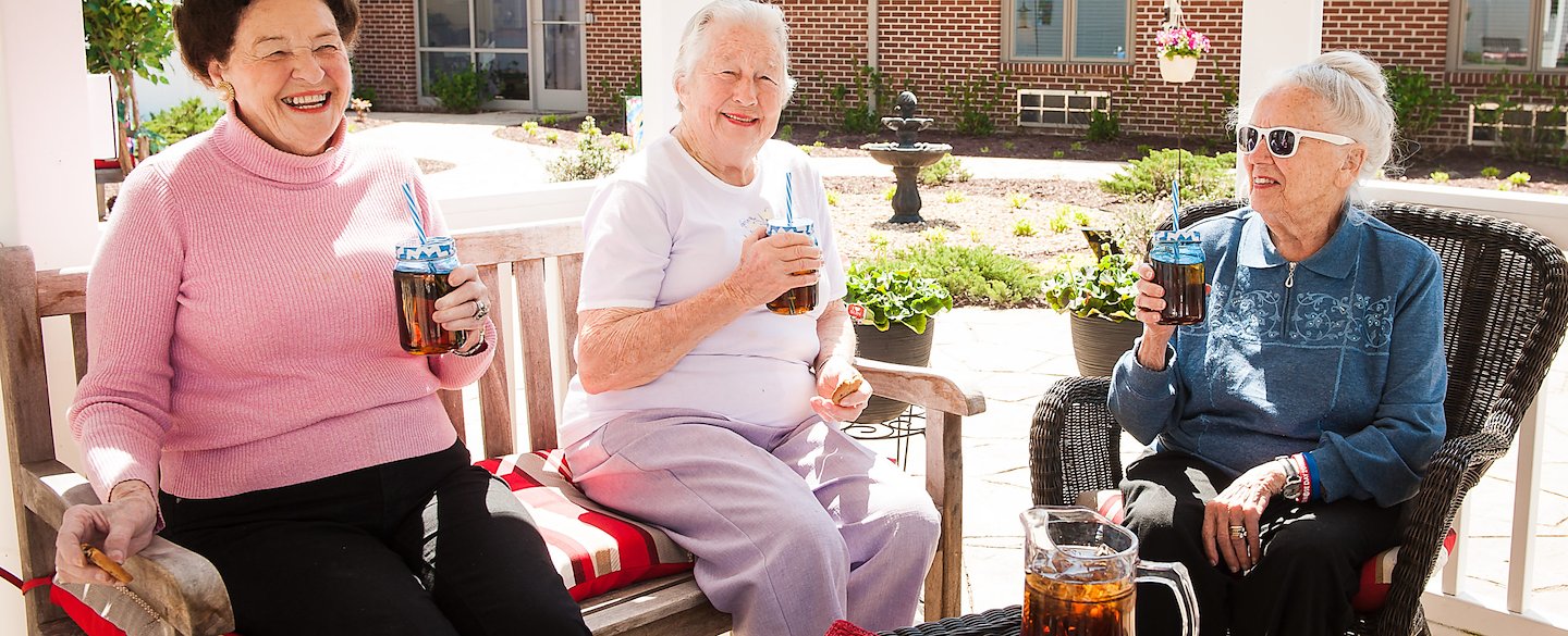 Three residents enjoying drinks on a patio