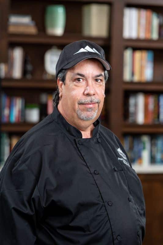 Chef posing in a well-lit kitchen area
