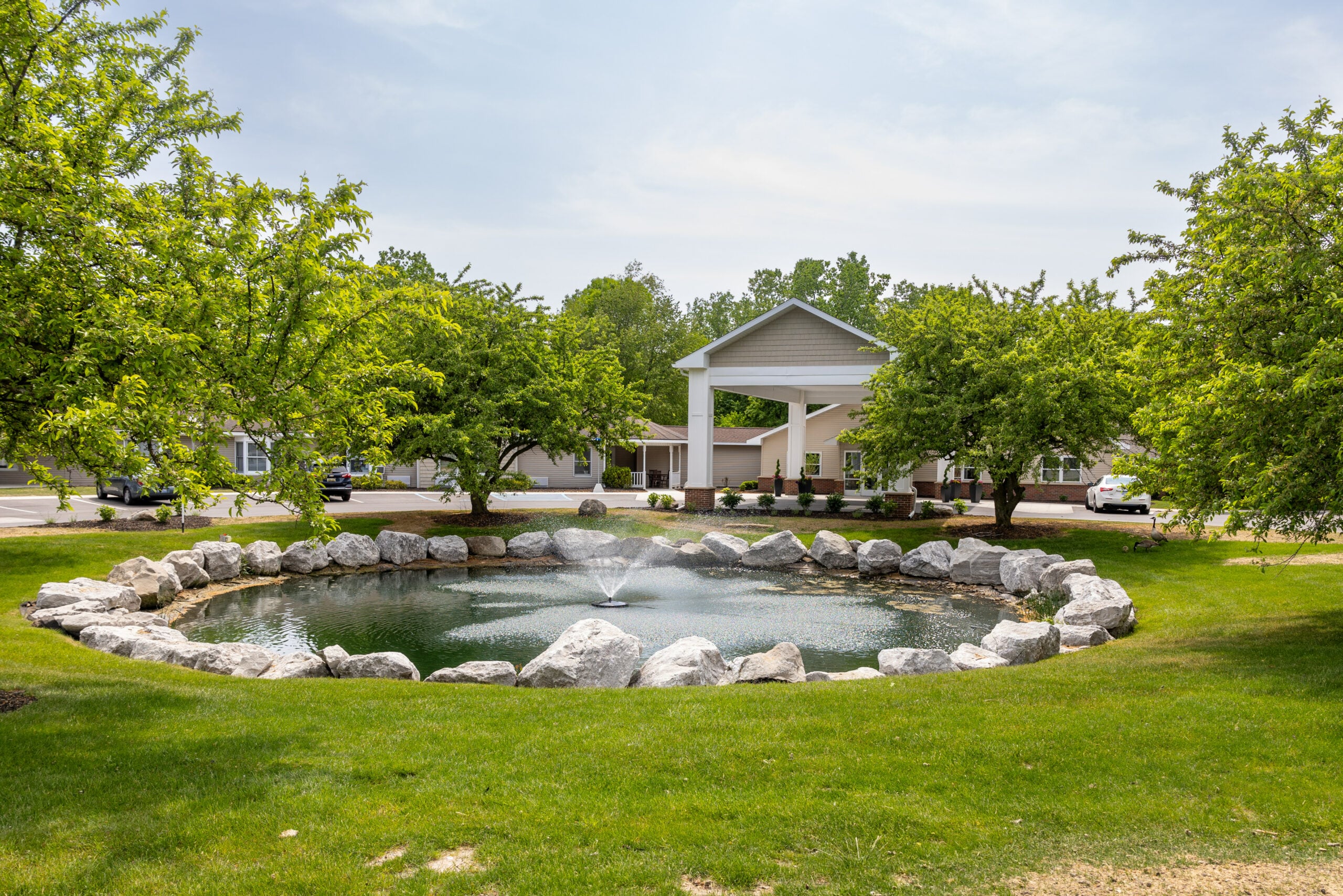 Exterior view of the facility entrance with a pond