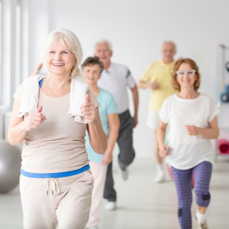 Seniors participating in a group exercise class indoors