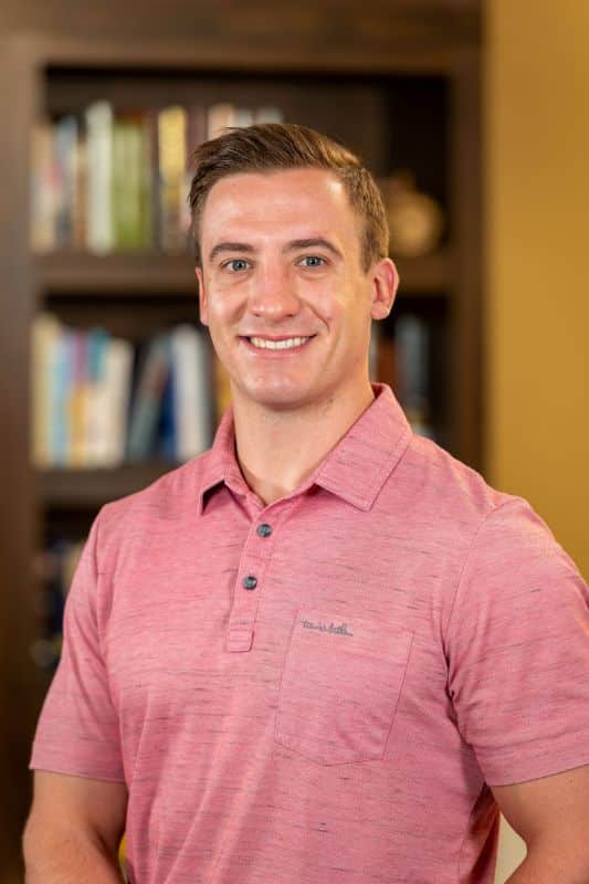 Staff member in a common area with bookshelves