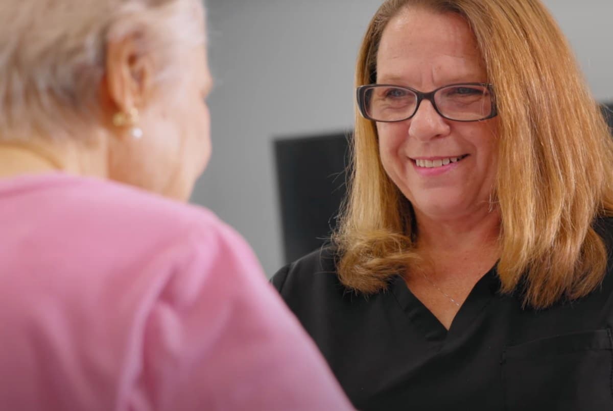A caregiver smiling while interacting with a resident