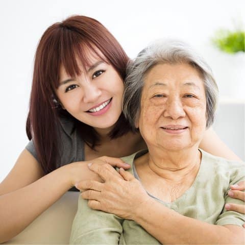 A caregiver with a senior resident smiling together