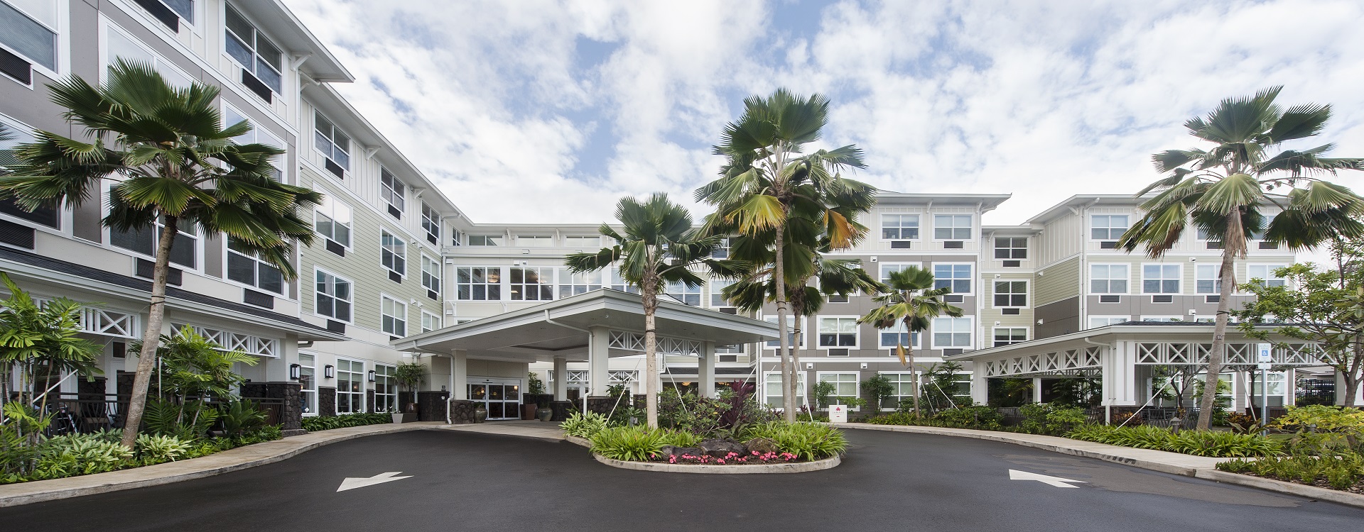 Front entrance of The Plaza Moanalualani with palm trees