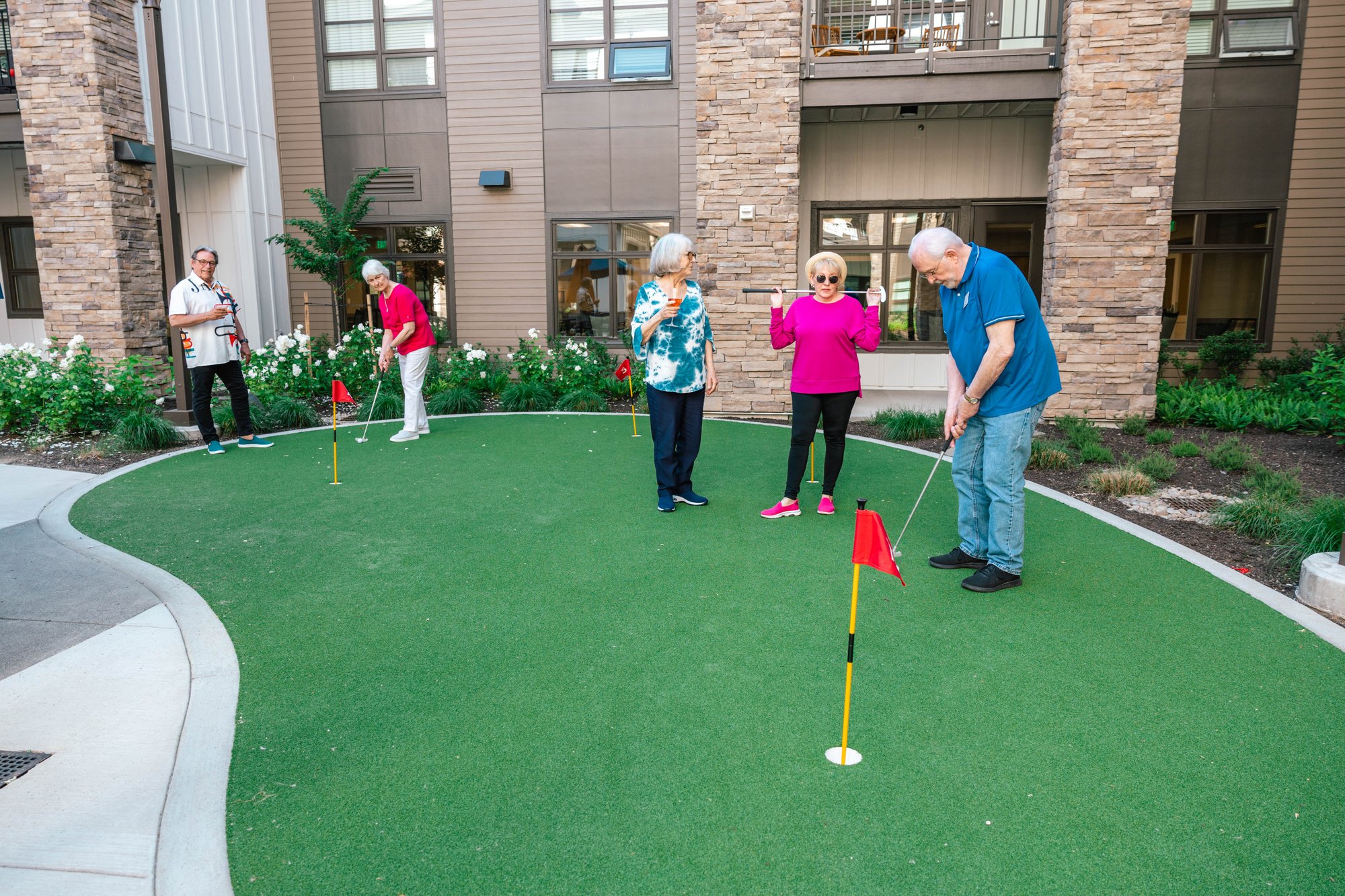 Residents enjoying putting greens in the outdoor space