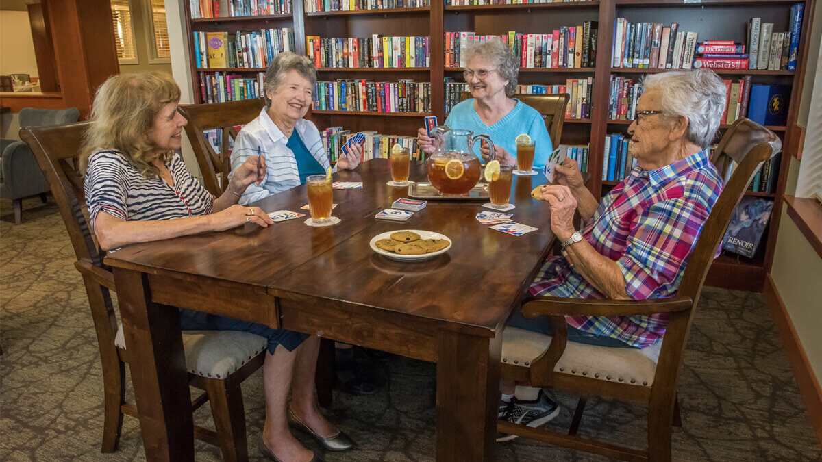 Residents enjoying a card game in a cozy common area