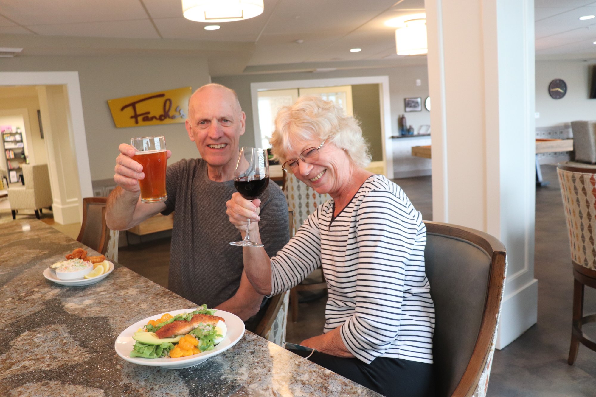 Two residents toasting with drinks in a common area
