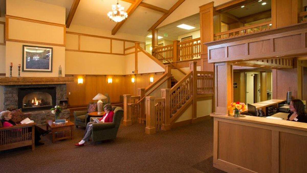 Residents relaxing in a cozy common area with a fireplace