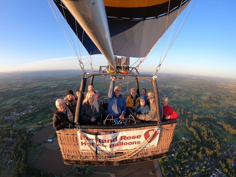 Group of people in a hot air balloon above the landscape