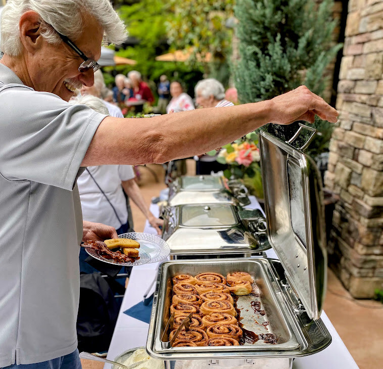 Resident enjoying a buffet meal with cinnamon rolls