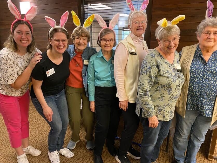 Residents and staff celebrating with bunny ears in a common area