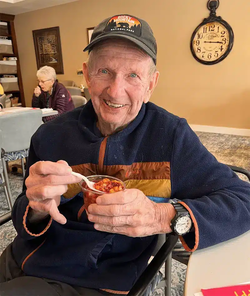 Resident enjoying dessert in a cozy common area