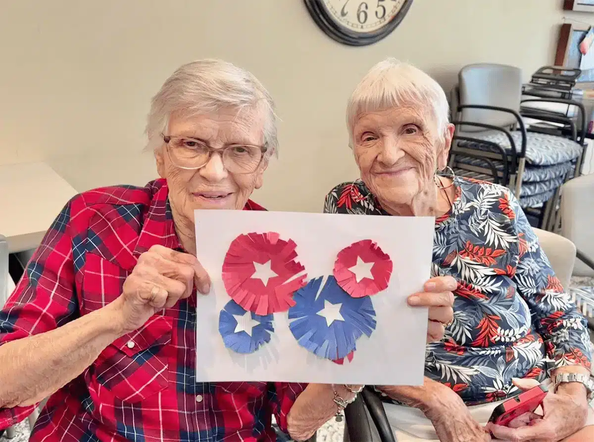 Two residents proudly displaying a craft project