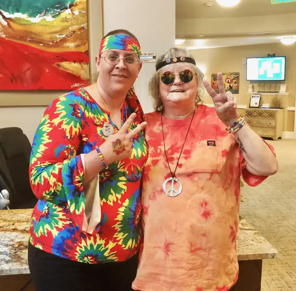 Staff and resident celebrating in colorful outfits