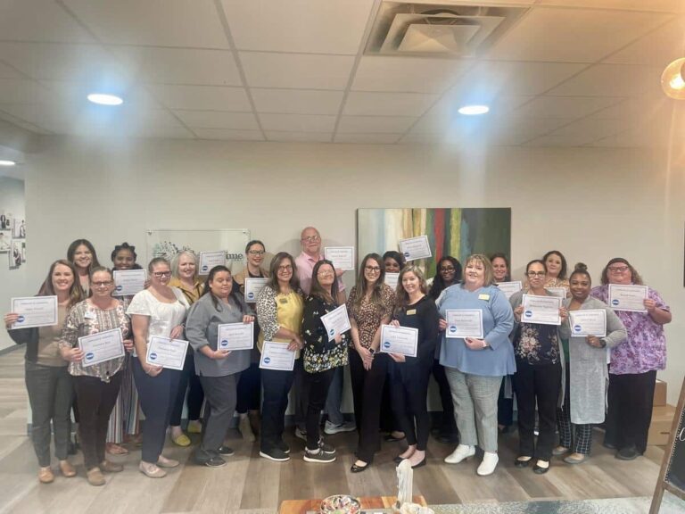 Staff members celebrating with certificates in a common area