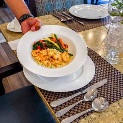 A staff member serving a meal in the dining room