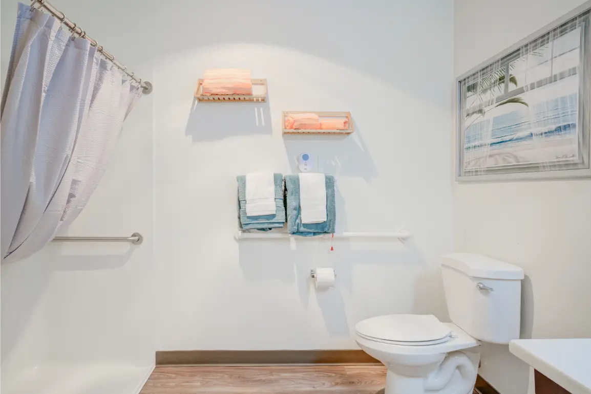 Well-lit bathroom with modern amenities and towels