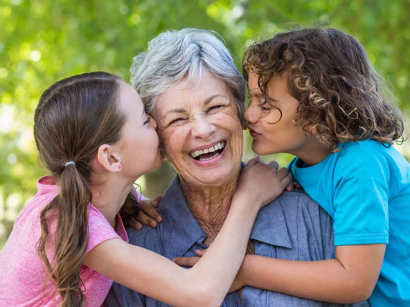 A smiling resident with two children outdoors