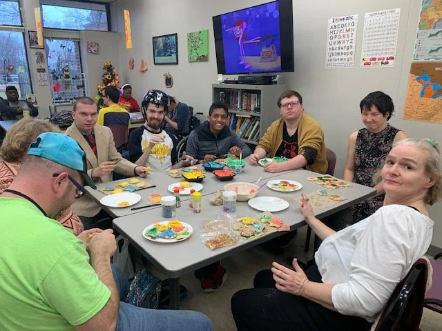 Residents decorating cookies in a common area.