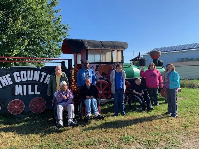 Residents and staff posing by a vintage train
