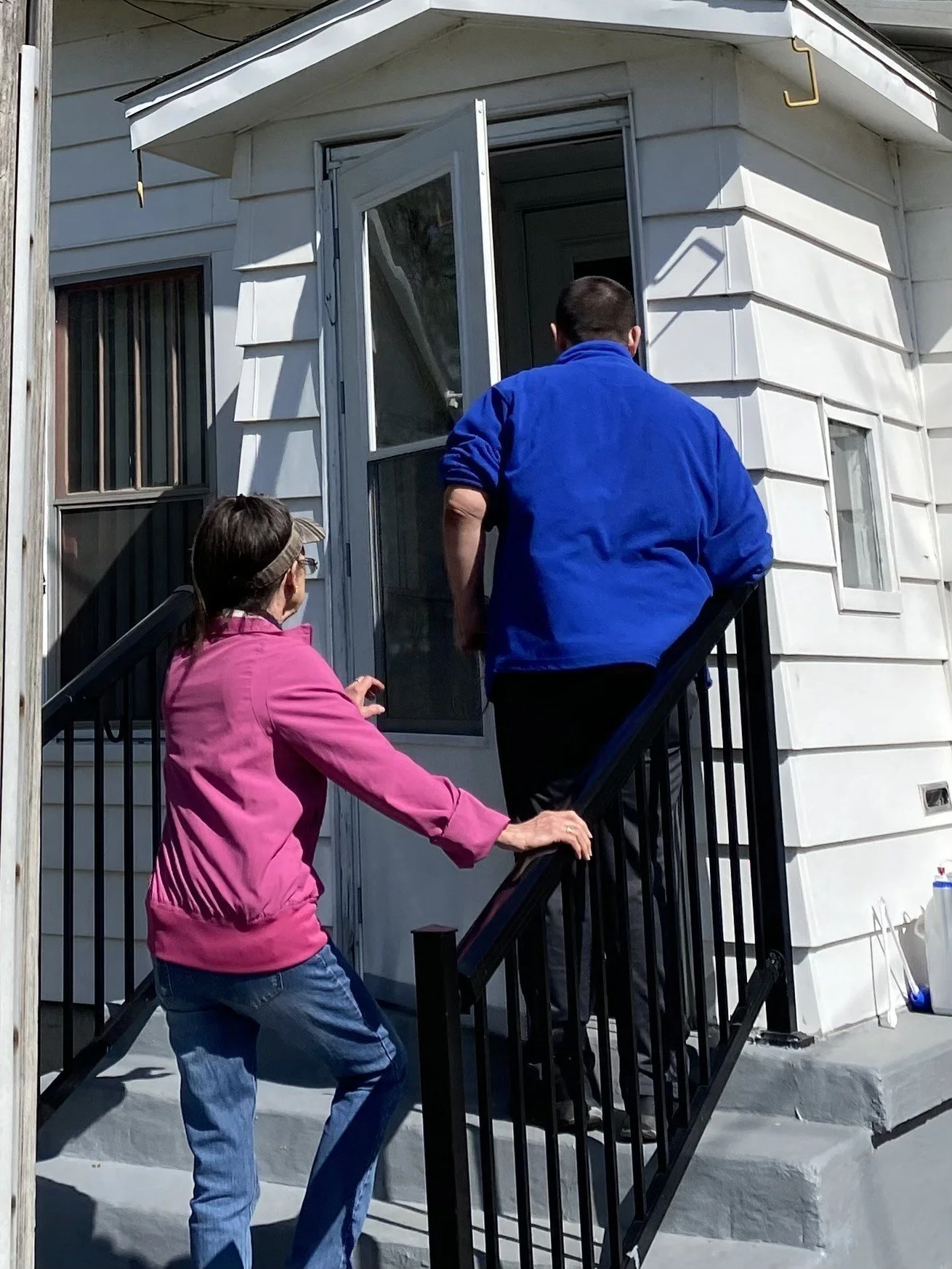Two individuals entering through a facility door.