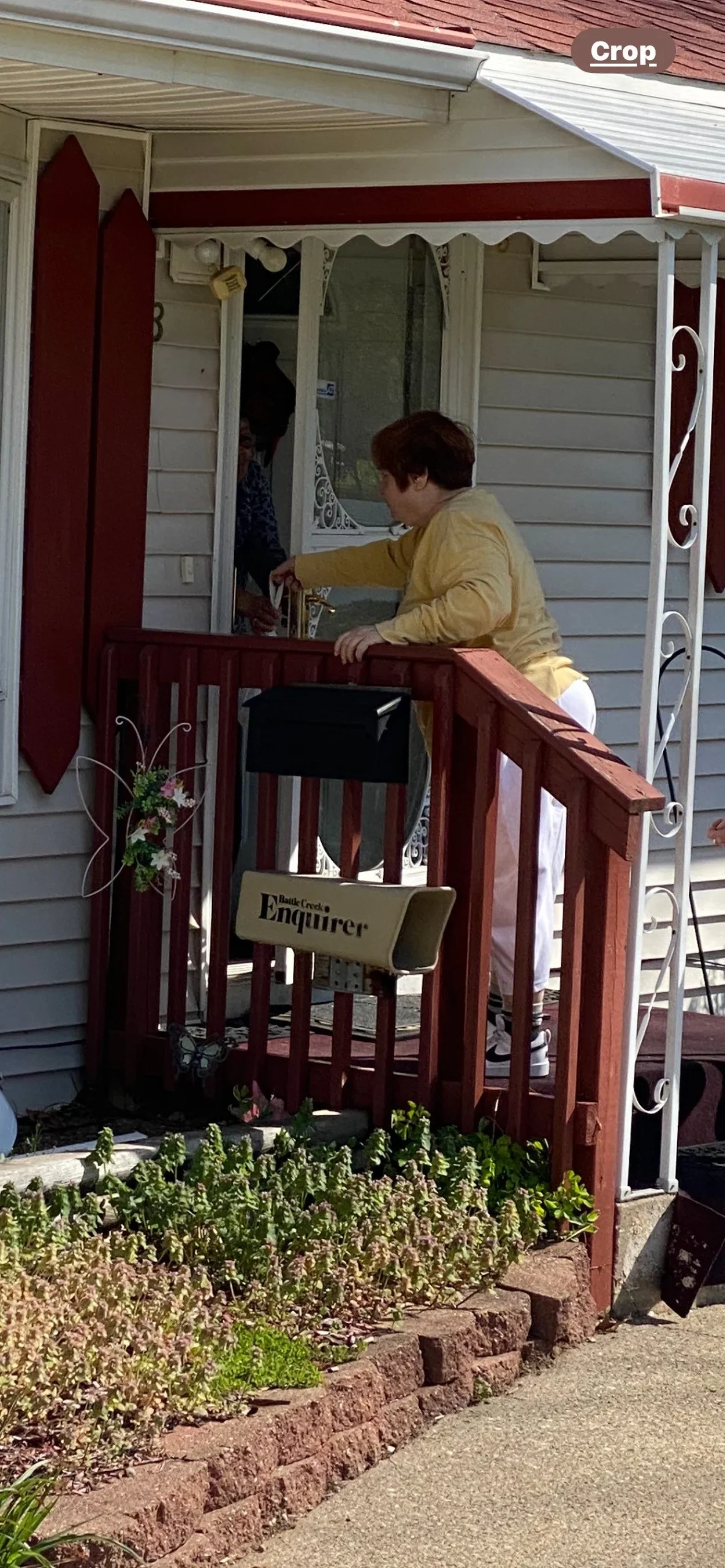 Resident interacting at a door on a porch.