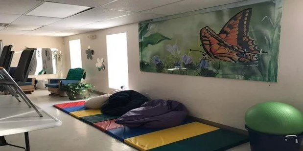 Interior space with colorful mats and a butterfly mural
