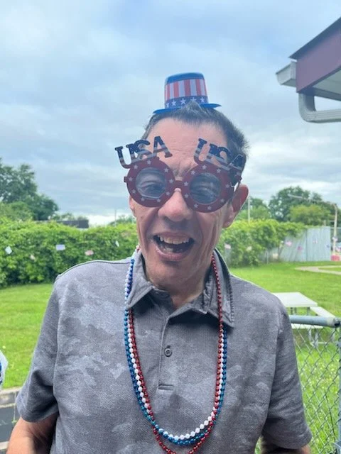 Resident celebrating with festive accessories outdoors.