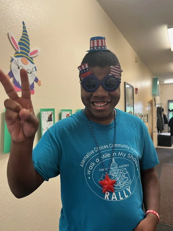 Resident with festive glasses and peace sign gesture