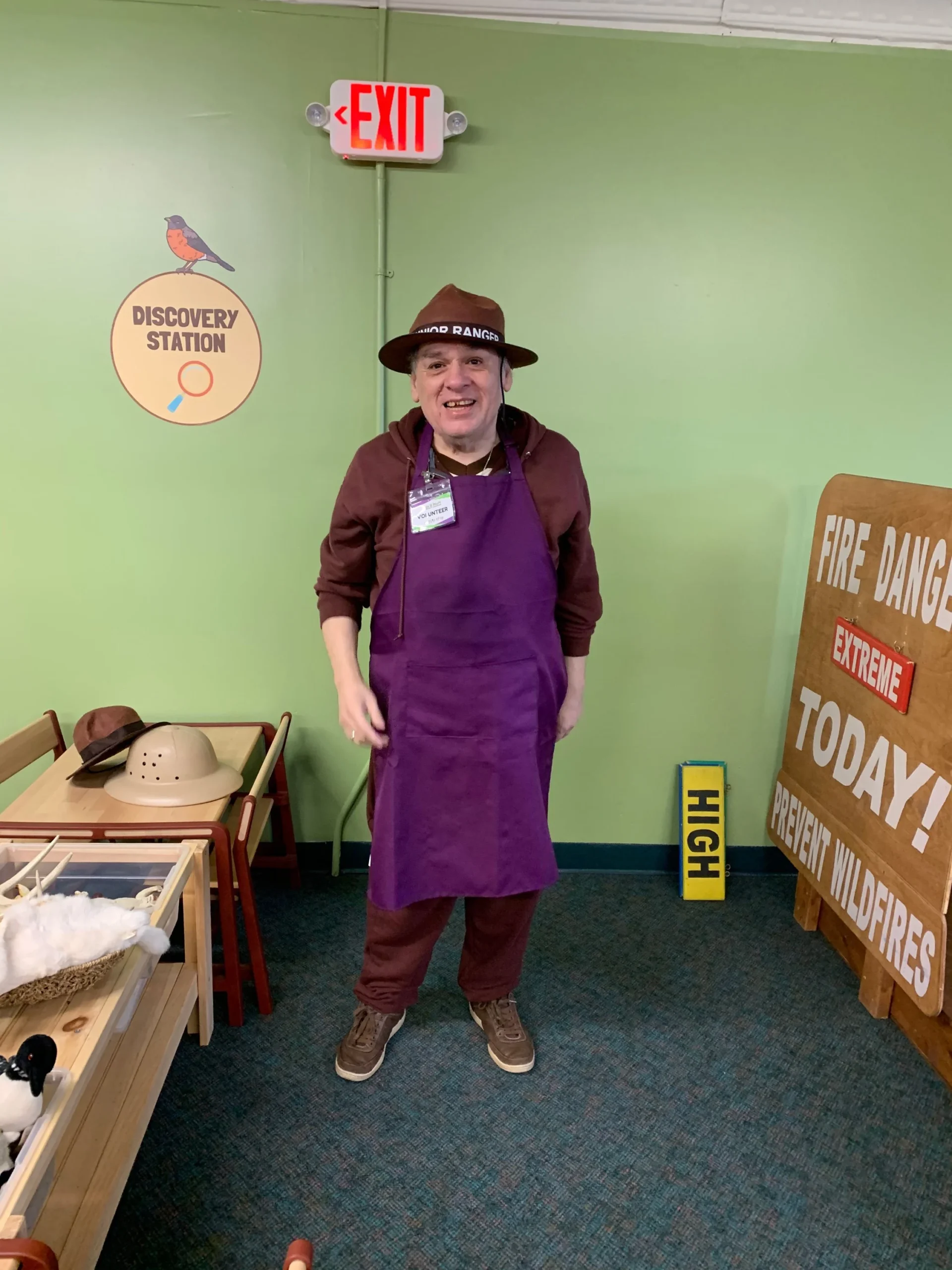Staff member in apron and hat, engaging in an activity.
