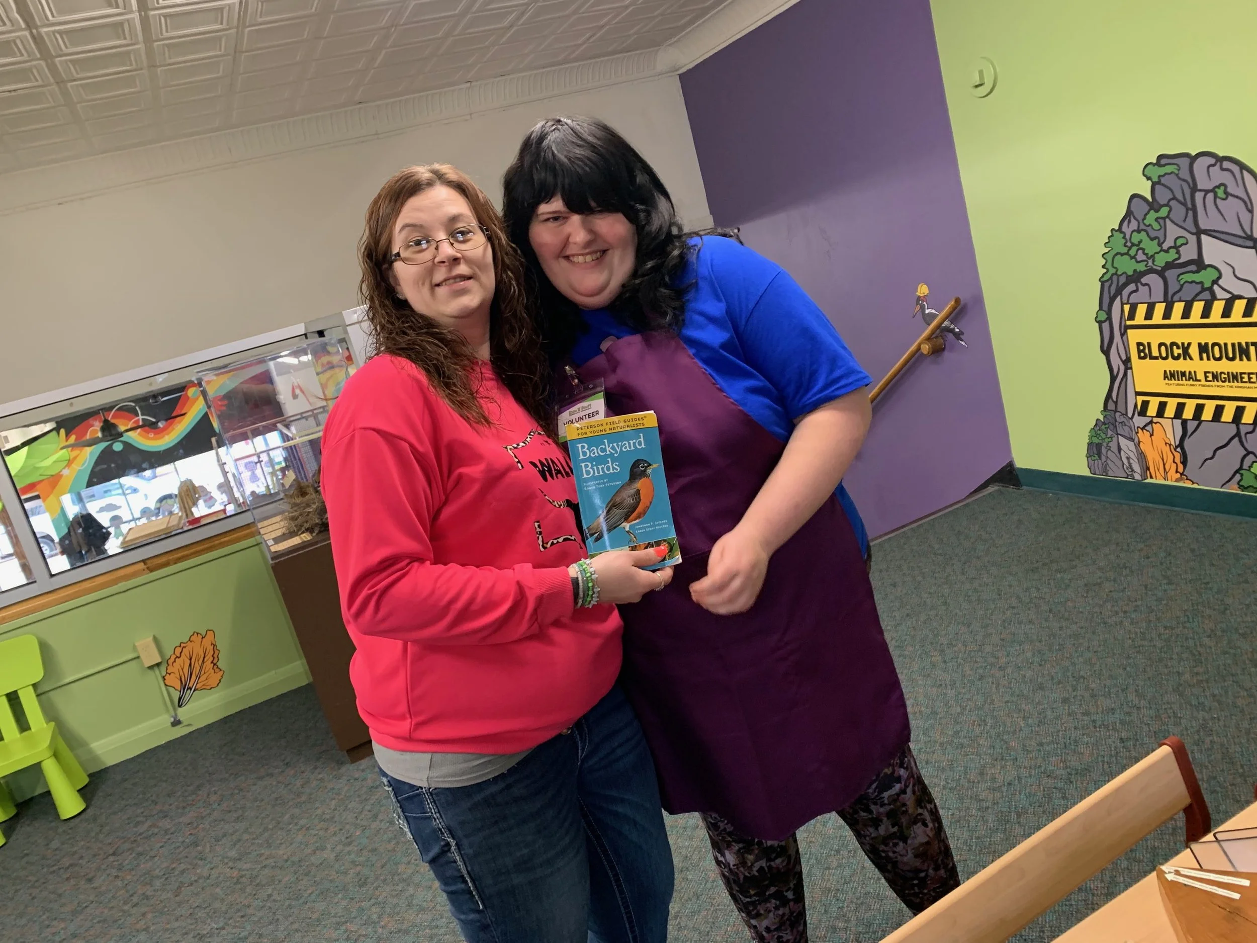 Two staff members posing together indoors.