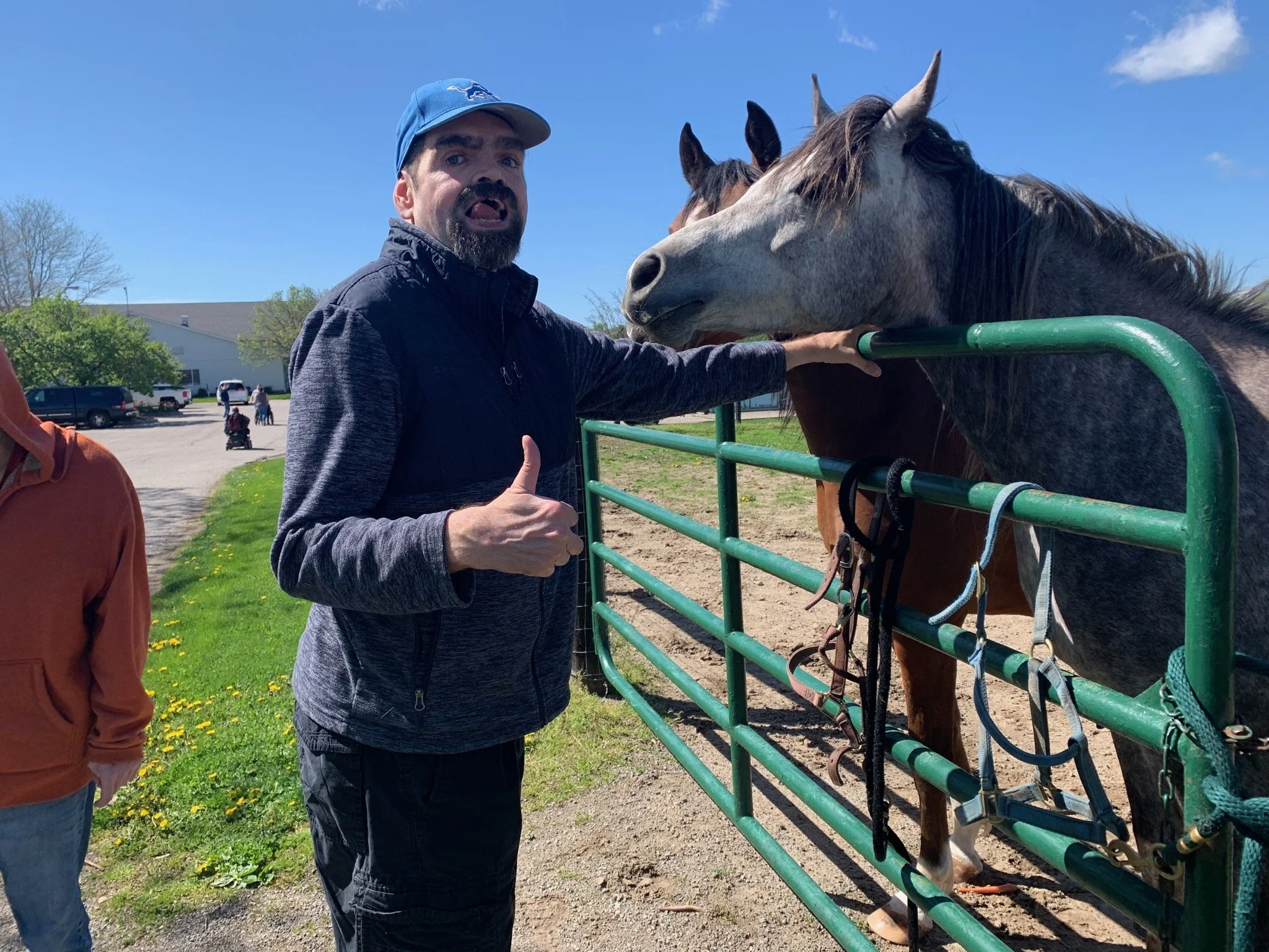 Resident interacting with horses in a farm setting.