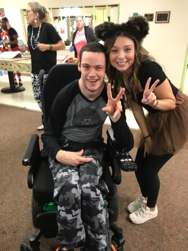 Resident and staff member posing during a celebration.