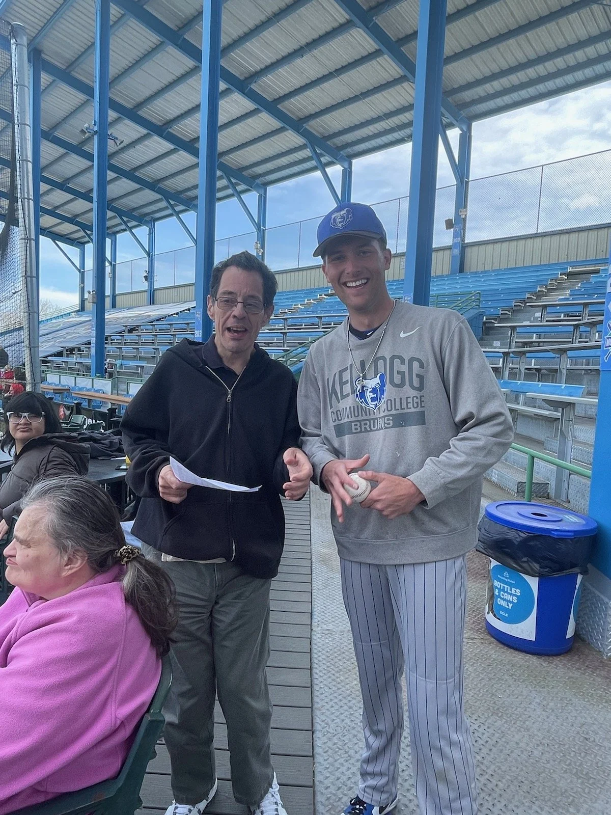 Residents enjoying time with visitors at a baseball game.