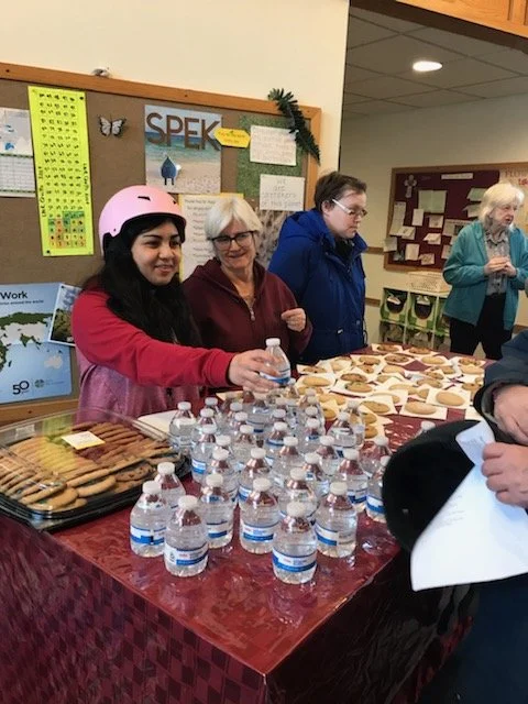 Residents and staff interacting at a food table.
