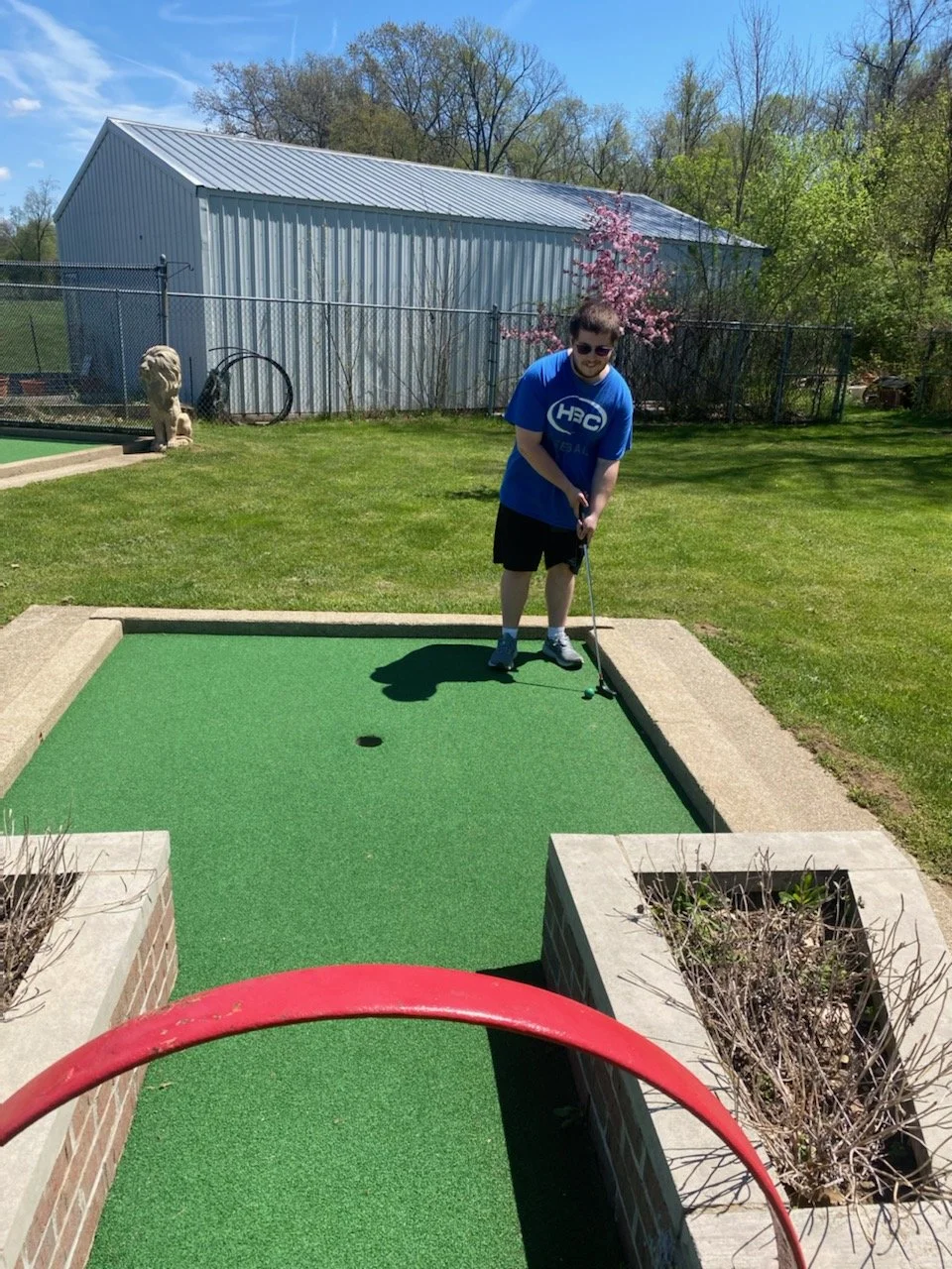 Person playing mini-golf in an outdoor area