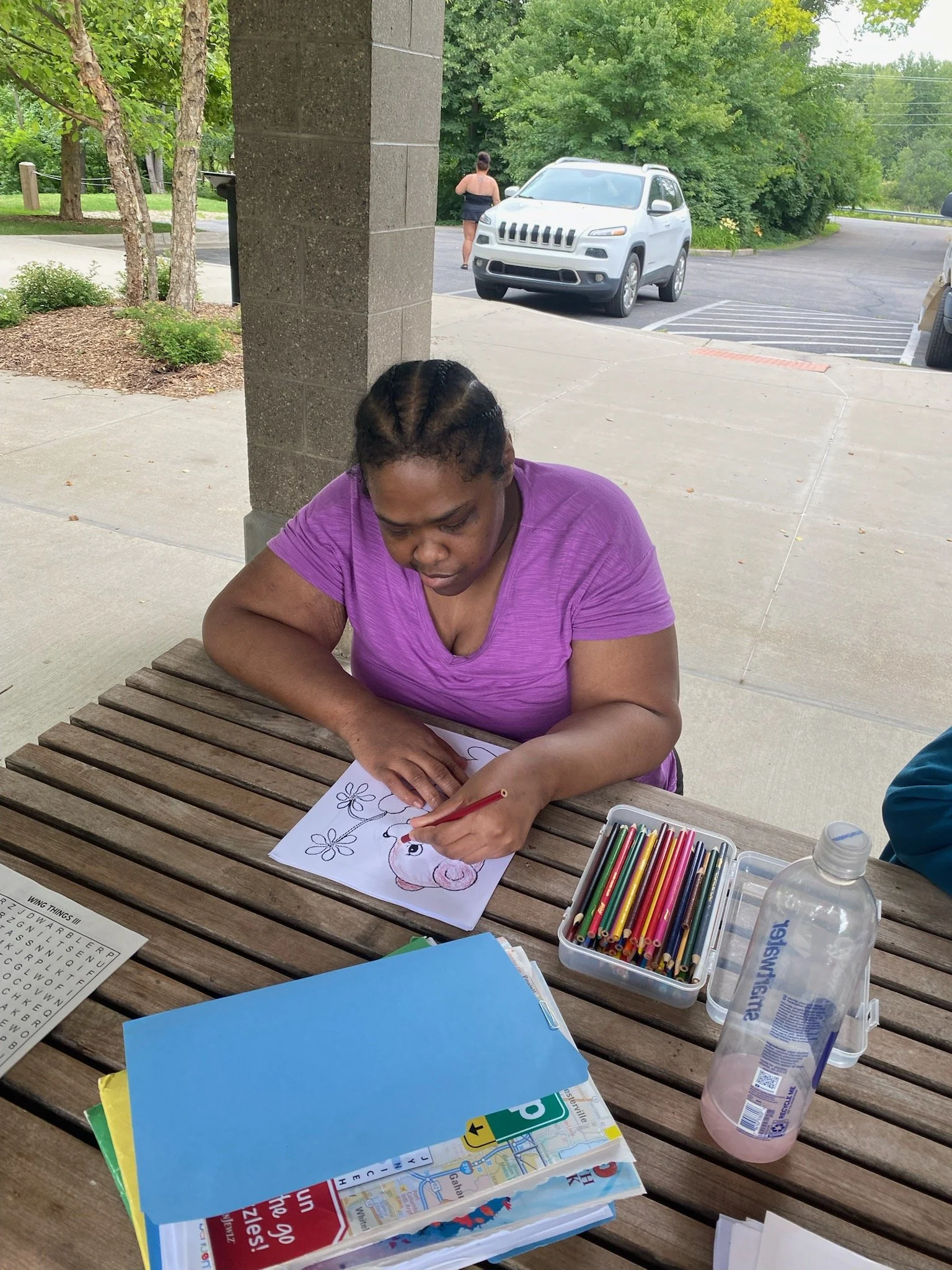 Resident coloring outdoors at a table.