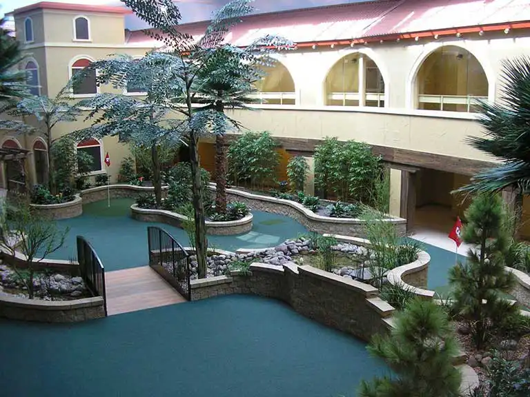 Indoor garden area with bridges and greenery.